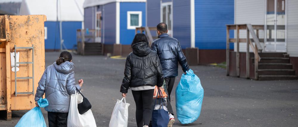 In Plastiksäcken tragen neu angekommene Flüchtlinge ihre persönlichen Habseligkeiten zu ihrer Unterkunft in der Erstaufnahmeeinrichtung (HEAE) in Gießen.