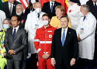 Kanzlerin Angela Merkel zwischen zwei Ärzten auf einem Foto beim G20-Gipfel. Foto: imago images/Italy Photo Press