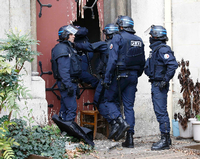 Französische Sicherheitskräfte brechen eine Tür in einer Kirche in Saint-Denis nahe des Einsatzortes auf. Die Hintergründe dafür sind unklar. Foto: REUTERS
