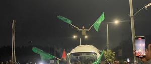 Palästinenser feiern die Ankunft von entlassenen Gefangenen mit Hamas-Flaggen.