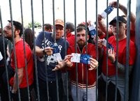 Fans des FC Liverpool warten vor dem Stadion und präsentieren ihre Karten. Foto: Imago/Sportimage/David Klein