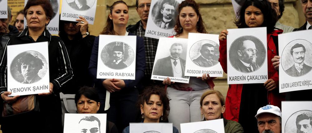 Türkische und armenische Bürger halten Bilder von getöteten armenischen Völkermordopfern.