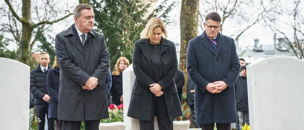 Claus Kaminsky (SPD, l-r), Oberbürgermeister von Hanau, Nancy Faeser (SPD), Bundesinnenministerin, und Boris Rhein (CDU), Ministerpräsident von Hessen, stehen auf dem Hanauer Hauptfriedhof zwischen Gräbern der Opfer. 