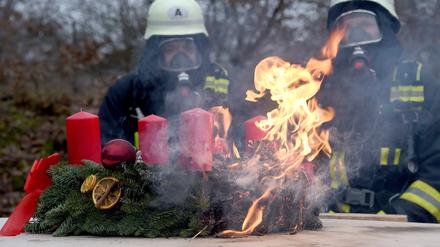 Die Feuerwehr demonstriert Gefahren durch brennenden Weihnachtsschmuck.