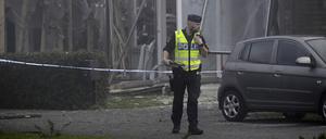 Ein Polizist steht am Ort einer starken Explosion, die sich am frühen Donnerstagmorgen in einem Wohngebiet in Storvreta außerhalb von Uppsala ereignete. Eine 25-jährige Frau kam bei der Explosion in Schweden ums Leben.