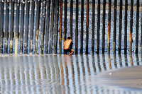 Ein Mann schaut in Tijuana von mexikanischer Seite aus durch den Grenzzaun in Richtung USA. Foto: Alejandro Zepeda/EFE/dpa