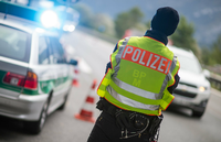 Ein Polizeibeamter beobachtet an der Anschlussstelle Bad Reichenhall der Autobahn A8 von Salzburg nach München Fahrzeuge, die aus Österreich kommen. dpa