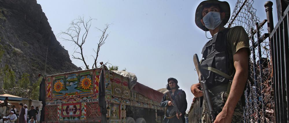Ein pakistanischer Soldat (r) und Kämpfer der Taliban stehen Wache an einem Grenzübergang zwischen Pakistan und Afghanistan in der Provinz Khyber Pakhtunkhwa auf den jeweiligen Seiten der Länder. 