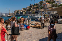 Touristen und Einheimische mit Maultieren stehen am Hafen der Insel Hydra, 65 Kilometer südwestlich von Athen entfernt. Foto: dpa / Angelos Tzortzinis