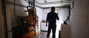 Ein Mitarbeiter eines Diesel- und Heizöl-Unternehmens prüft die Kunststofftanks in einem Heizungskeller bei der Heizöllieferung für ein Einfamilienhaus.