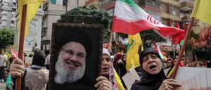 Ein Hisbollah-Anhänger hält ein Porträt des Hisbollah-Chefs Hassan Nasrallah hoch.