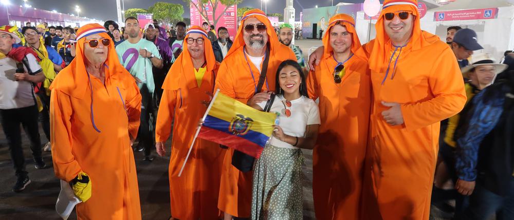 Ein ecuadorianischer Fan vor niederländischen Fans in katarischer Robe
