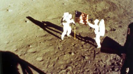 Neil Armstrong und Buzz Aldrin an der US-amerikanischen Flagge.