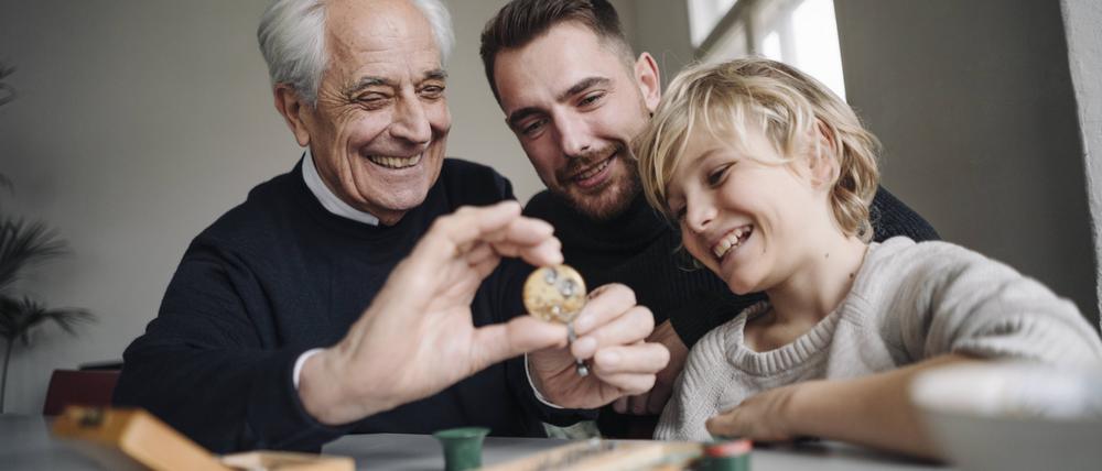 Happy watchmaker showing clockwork to young man and boy model released Symbolfoto property released PUBLICATIONxINxGERxSUIxAUTxHUNxONLY GUSF02178  
