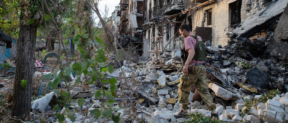 Ein russischer Separatist inspiziert zerstörte Gebäude im eroberten Sjewjerodonezk.