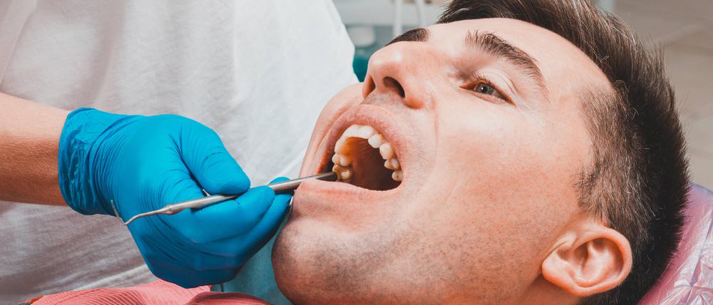 Ein Mann liegt auf dem Behandlungsstuhl beim Zahnarzt. Ab 2025 soll Amalgam am Zahnfüllung verboten sein.