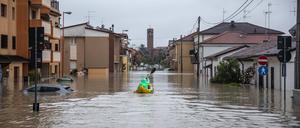 Ein Bürger fährt am 16. Mai in Cesena mit einem aufblasbaren Kajak zwischen den überschwemmten Häusern hin und her, um einige im Haus festsitzende Personen an Land zu bringen.