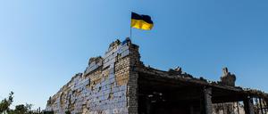Eine ukrainische Flagge weht auf einem zerstörten Gebäude in Donezk.