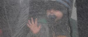 Ein Kind schaut am 20. April 2022 am Kontrollpunkt Verigovka-Chugunovka in der Region Belgorod (Russland) aus dem Fenster eines Busses.