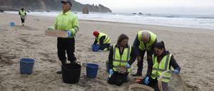 Freiwillige säubern den Strand in Muros de Nalon, Spanien.