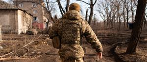 Ein Soldat läuft in der Stadt Chasiv Yar (Donezk) neben zerstörten Gebäuden, die von russischen Bomben getroffen wurden. 