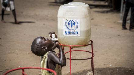 Ein geflüchtetes Kind aus dem Südsudan trinkt am 26. Mai 2017 in Uganda aus einem Wassertank der UNCHR.