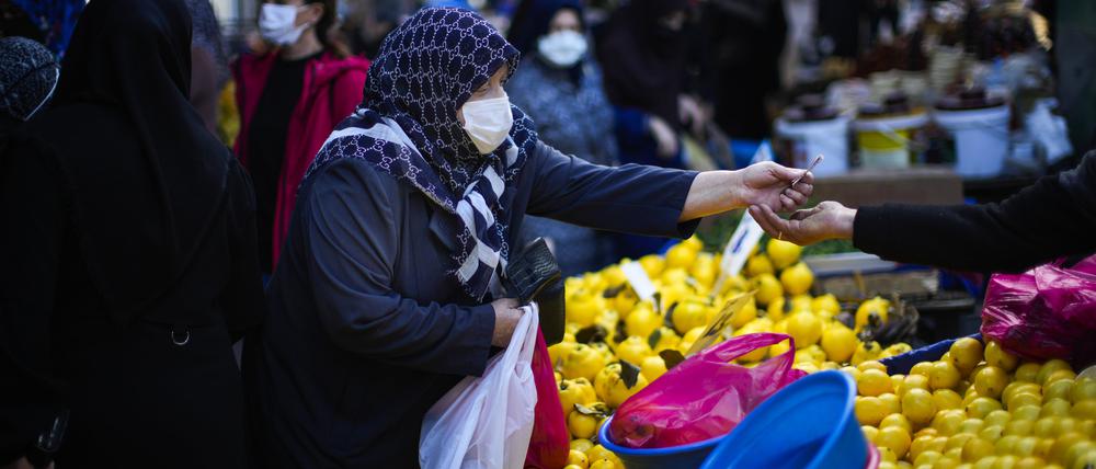 Türkei, Istanbul: Eine Frau kauft auf dem Ortakcilar-Straßenmarkt ein.