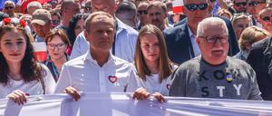 Oppositionsführer Donald Tusk und Lech Walesa, Gründer der Gewerkschaft Solidarnosc und Friedensnobelpreisträger, marschieren mit jungen  Polinnen in der ersten Reihe bei der Kundgebung in Warschau. 