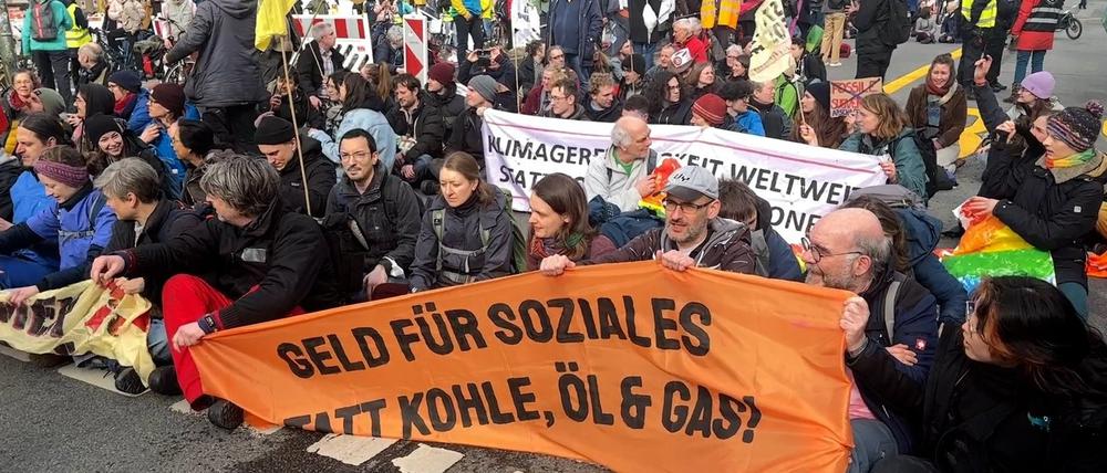 02.03.2024, Berlin: Aktivisten blockieren eine Straße in Berlin, und demonstrieren unter dem Motto "Stoppt Fossile Subventionen". Sie fordern dabei mit einem Transparent "Geld für Soziales, statt Kohle, Öl und Gas!". Foto: Lutz Deckwert/TNN/dpa +++ dpa-Bildfunk +++