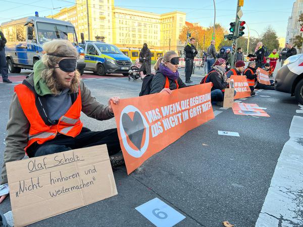 Demonstranten haben sich am Frankfurter Tor an die Straße geklebt. Sie demonstrieren gegen die nach ihrer Meinung zu geringen Maßnahmen der Politik gegen den Klimawandel. 