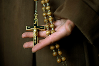 Kruzifix und Rosenkranz in der Hand einer Novizin Foto: dpa/Arno Burgi