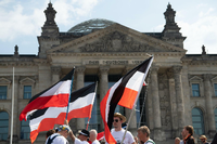 Mit Reichsfahnen stehen Teilnehmer einer „Mahnwache für Heimat- und Weltfrieden“ am vergangenen Wochenende auf der Wiese vor dem Reichstag. Foto: Paul Zinken/dpa