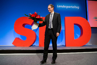 Michael Müller (SPD), Regierender Bürgermeister, lächelt beim Landesparteitag der SPD Berlin. Foto: Jörg Carstensen/dpa