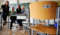 Schüler und Schülerinnen sitzen mit ihrer studentischen Nachhilfelehrerin in einem Klassenraum. Foto: Clemens Bilan/ddp images/dapd