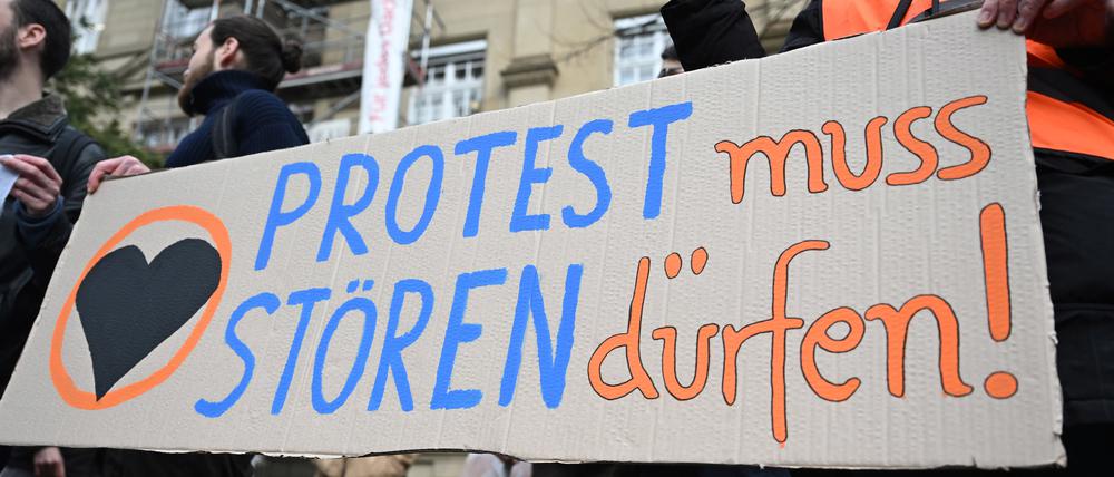 Vor dem Oberlandesgericht (OLG) Karlsruhe protestieren Klimaaktivisten mit einem Plakat auf dem steht «Protest muss stören dürfen!» gegen den Prozess, ob Straßenblockaden von Klimaaktivisten als Nötigung einzustufen sind. 