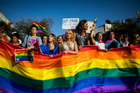 Menschen marschieren mit Regenbogenfahnen und Schildern während der jährlichen Gay-Pride-Parade in Jerusalem. Foto: Ilia Yefimovich/dpa