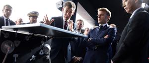 Der Präsident der französischen Raumfahrtagentur CNES, Philippe Baptiste, und der Präsident der Japanischen Agentur für Luft- und Raumfahrt (JAXA), Hiroshi Yamakawa (r), zeigen dem französischen Präsidenten Emmanuel Macron (2.v.r.) auf der Internationalen Pariser Luftfahrtausstellung das Modell „Idefix“.
