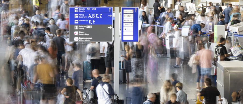 Tausende Passagiere warten vor den Abfertigungsschaltern des Flughafens auf ihren Check-In.