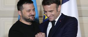 Wolodymyr Selenskyj (l), Präsident der Ukraine, und Emmanuel Macron, Präsident von Frankreich, geben sich nach einer Pressekonferenz im Elysee-Palast die Hand. 