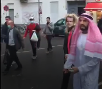 Rechts im Bild der Youtuber Fayez Kanfash, links neben ihm zerrt er die Person mit Macron-Maske hinter sich her. Das Video wurde von einem Passanten aufgenommen. Foto: TSP