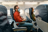 Flugpassagiere tragen Mund-Nasen-Schutz während eines Fluges (Symbolbild) Foto: mauritius images/Alamy/Yaroslav Astakhov