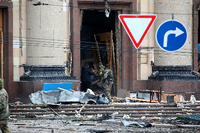 Ukrainische Soldaten und ein Zivilist hantieren vor einem Verwaltungsgebäude in Charkiv mit zerstörten Möbeln. Foto: imago images/Ukrinform