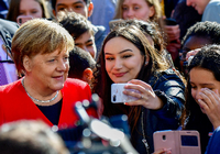Auf gleicher Selfiehöhe: Was für die Kanzlerin - hier beim EU-Projekttag an einer Berliner Schule am Dienstag - selbstverständlich ist, sieht am Arbeitsplatz für Menschen mit Migrationsgeschichte oft ganz anders aus. Foto: Tobias Schwarz/AFP