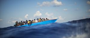 Migranten sitzen im Augist 2022 einem Holzboot südlich der italienischen Insel Lampedusa auf dem Mittelmeer.
