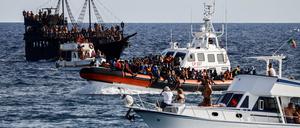 Zwischen Touristenbooten bringt ein Schiff der italienischen Küstenwache gerettete Migranten zur Mittelmeerinsel Lampedusa. 