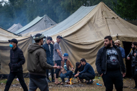 Migranten bereiten in einem neu errichteten Flüchtlingslager auf dem Truppenübungsplatz Rudninkai Essen zu. Foto: dpa/Mindaugas Kulbis