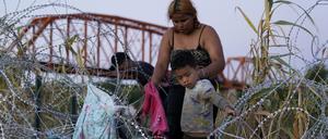 Migranten klettern über den Stacheldraht, nachdem sie den Rio Grande überquert und die USA von Mexiko aus betreten haben.
