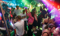 Besucher tanzen in der Diskothek Joy in Schleswig-Holstein, die einen höchstens sechs Stunden alten Schnelltes zur Voraussetzung für Tanzen ohne Mund-Nasen-Schutz macht. Foto: Markus Scholz/dpa