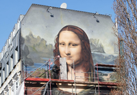 Die übergroße Mona Lisa blickt auf die Straße an der East Side Gallery. Foto: Annette Riedl/dpa