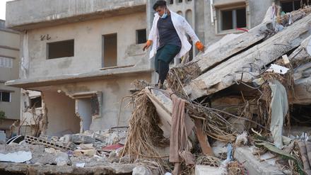 Ein Retter arbeitet an einem beschädigten Gebäude in Darna, Libyen. Nach Angaben des UN-Nothilfebüros (OCHA) kamen allein in der stark zerstörten Hafenstadt Darna rund 11.300 Menschen ums Leben. 